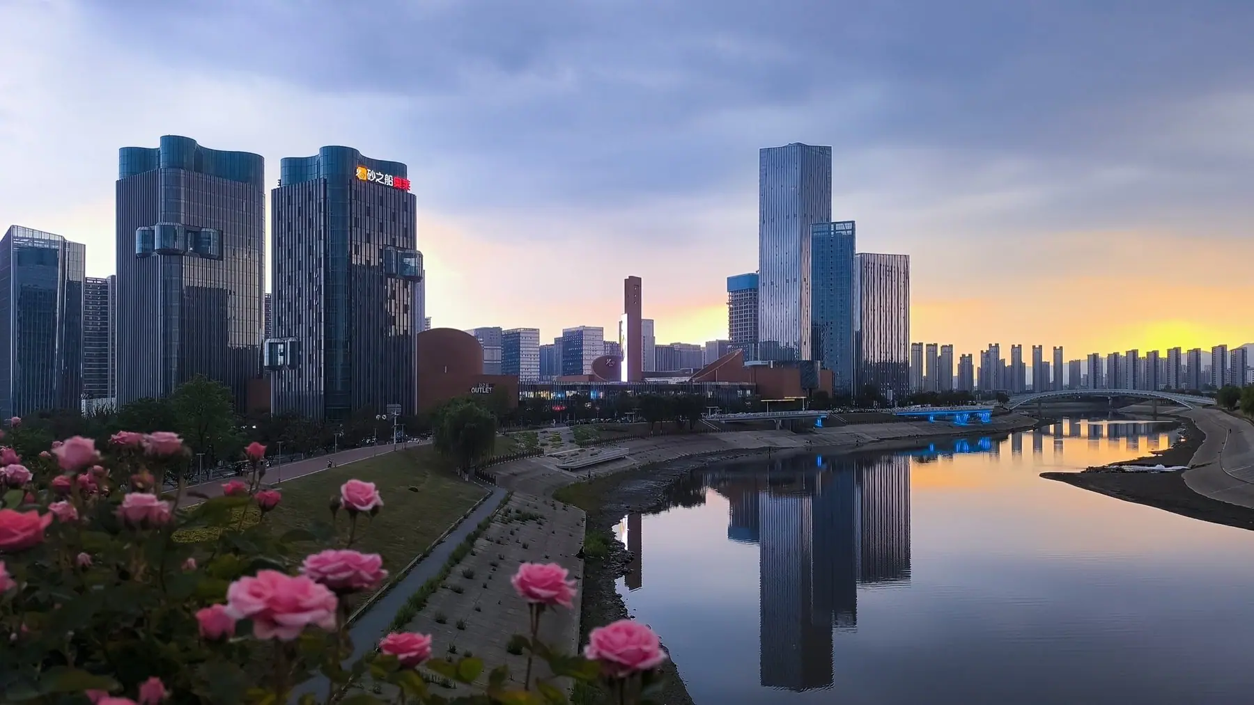 城市滨水商圈傍晚天际线，展现洄游将低效空间转化为可经营城市旅居产品的运营方向